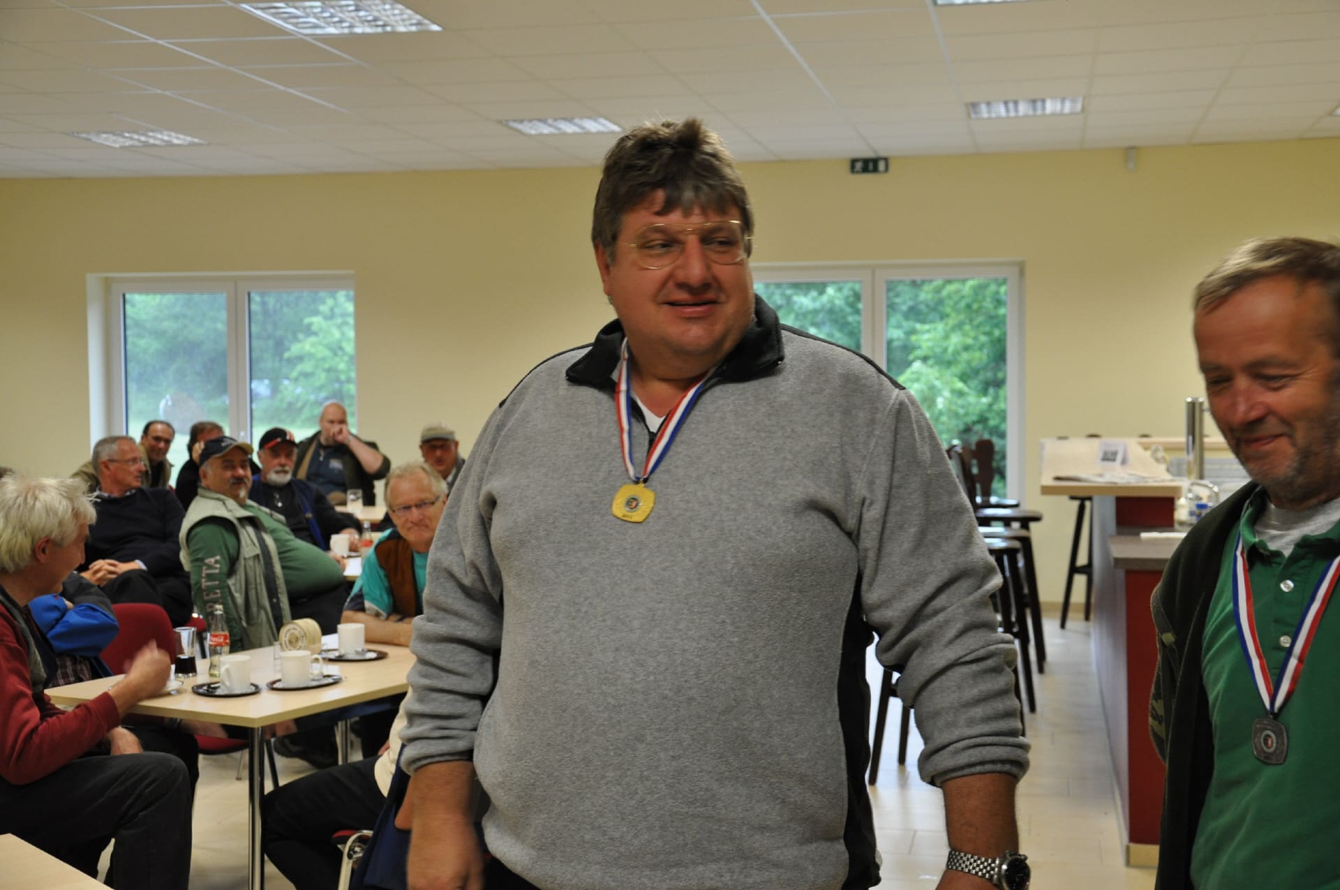 Ein Schütze mit Goldmedaille vor den Gästen der Siegerehrung